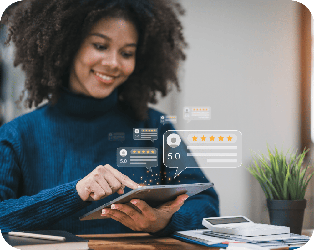 A woman smiling while using a tablet, with digital 5-star ratings and review icons above the device, suggesting this Denver engineer is engaging with civil engineering feedback or project reviews online at her desk.